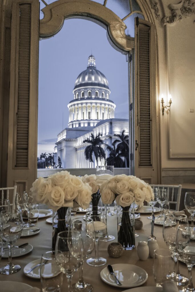 Luxury table decorated with white roses at the Havana Club 1519 event with a view of the Capitol of Havana