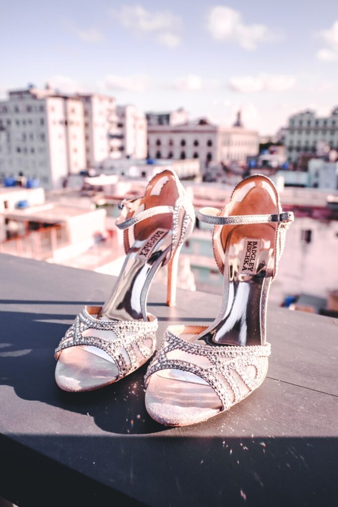 Zapatos de novia brillantes sobre baranda con edificios de La Habana de fondo