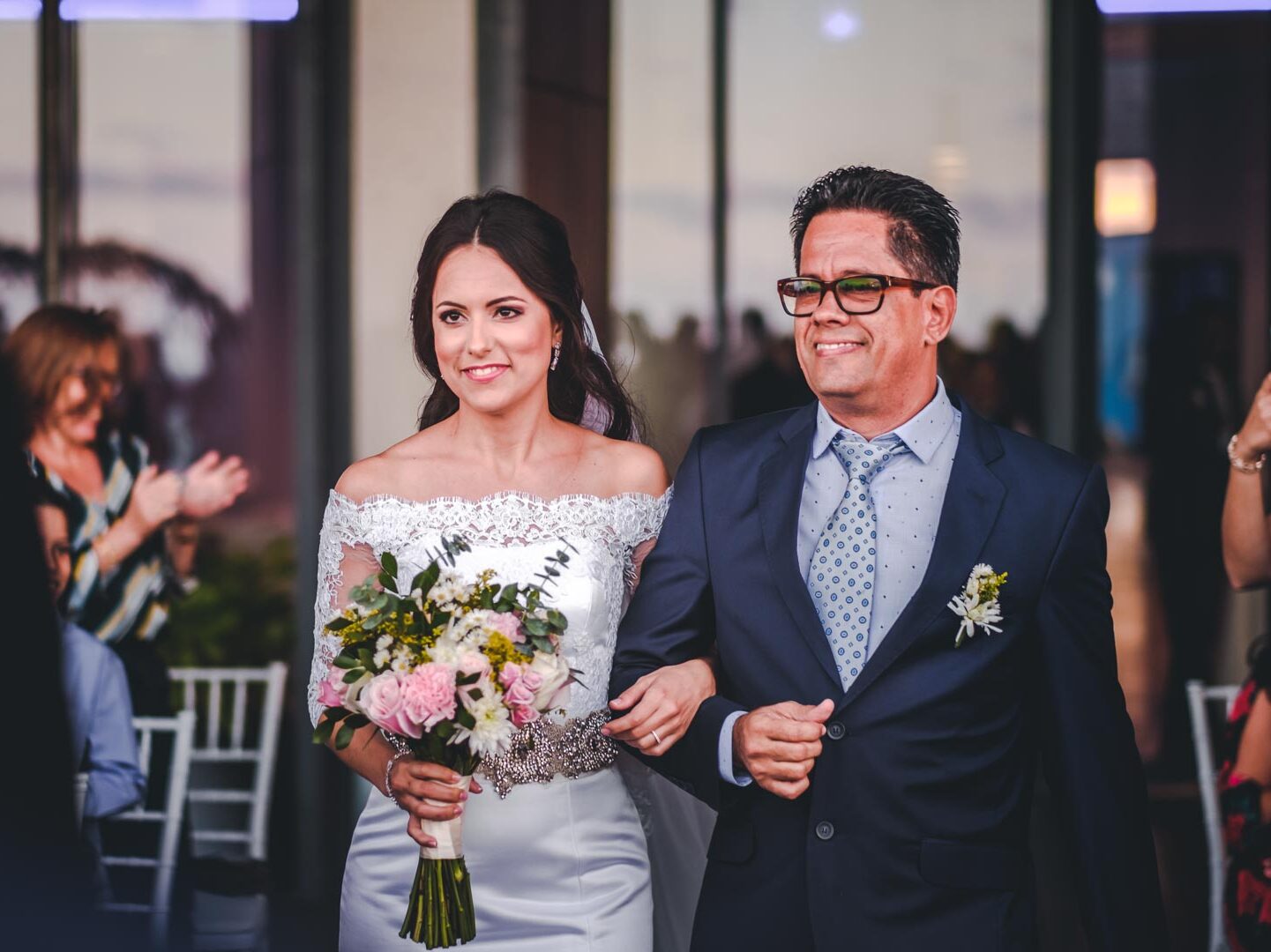 Novia entrando del brazo de su padre en la boda en el Hotel Grand Packard