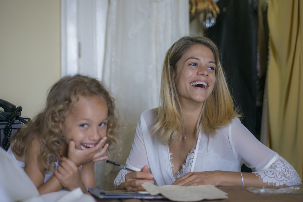 La novia escribe los votos mientras su hija la observa con gesto cómplice