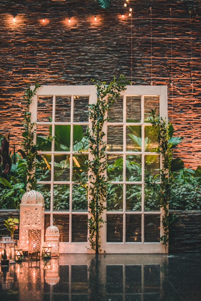 Puertas blancas con enredaderas y faroles iluminados en decoración del Hotel Grand Packard