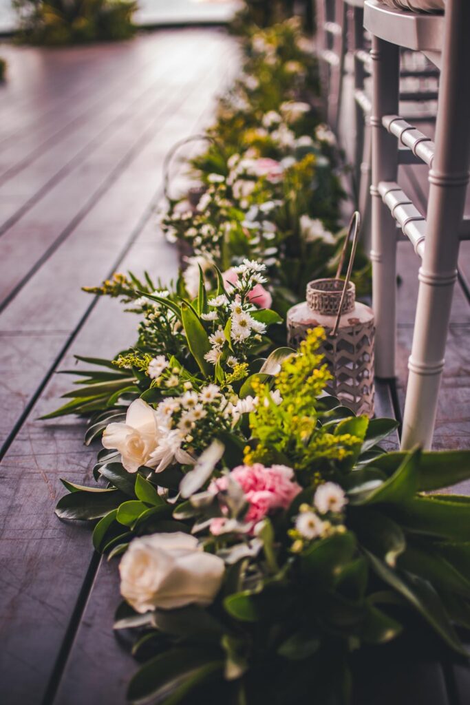 Decoración floral con rosas y follaje en el pasillo de ceremonia del Hotel Grand Packard