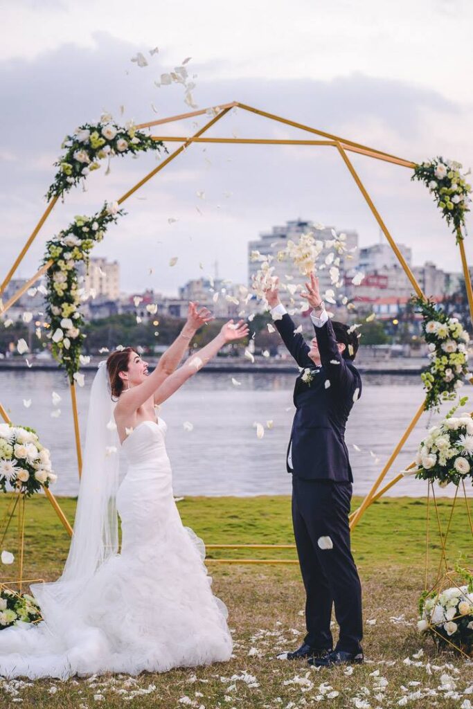 Wedding ceremony at La Divina Pastora with petal toss and geometric structure.