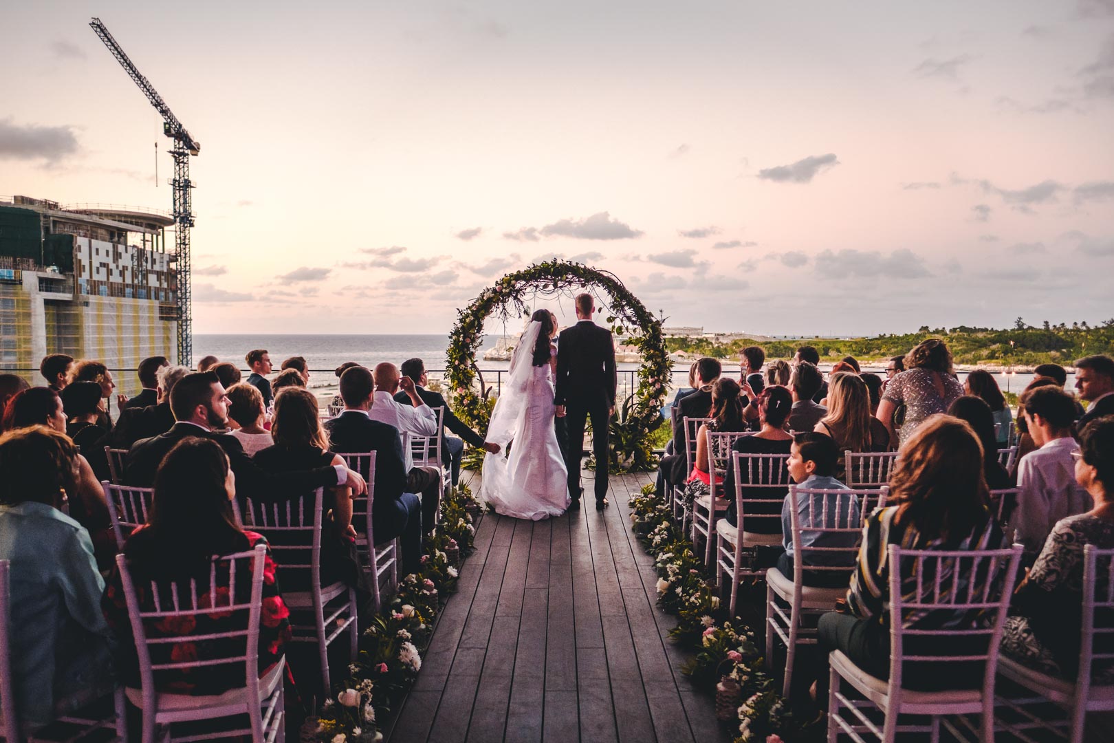 Novios frente al altar circular en ceremonia al atardecer en el Hotel Packard