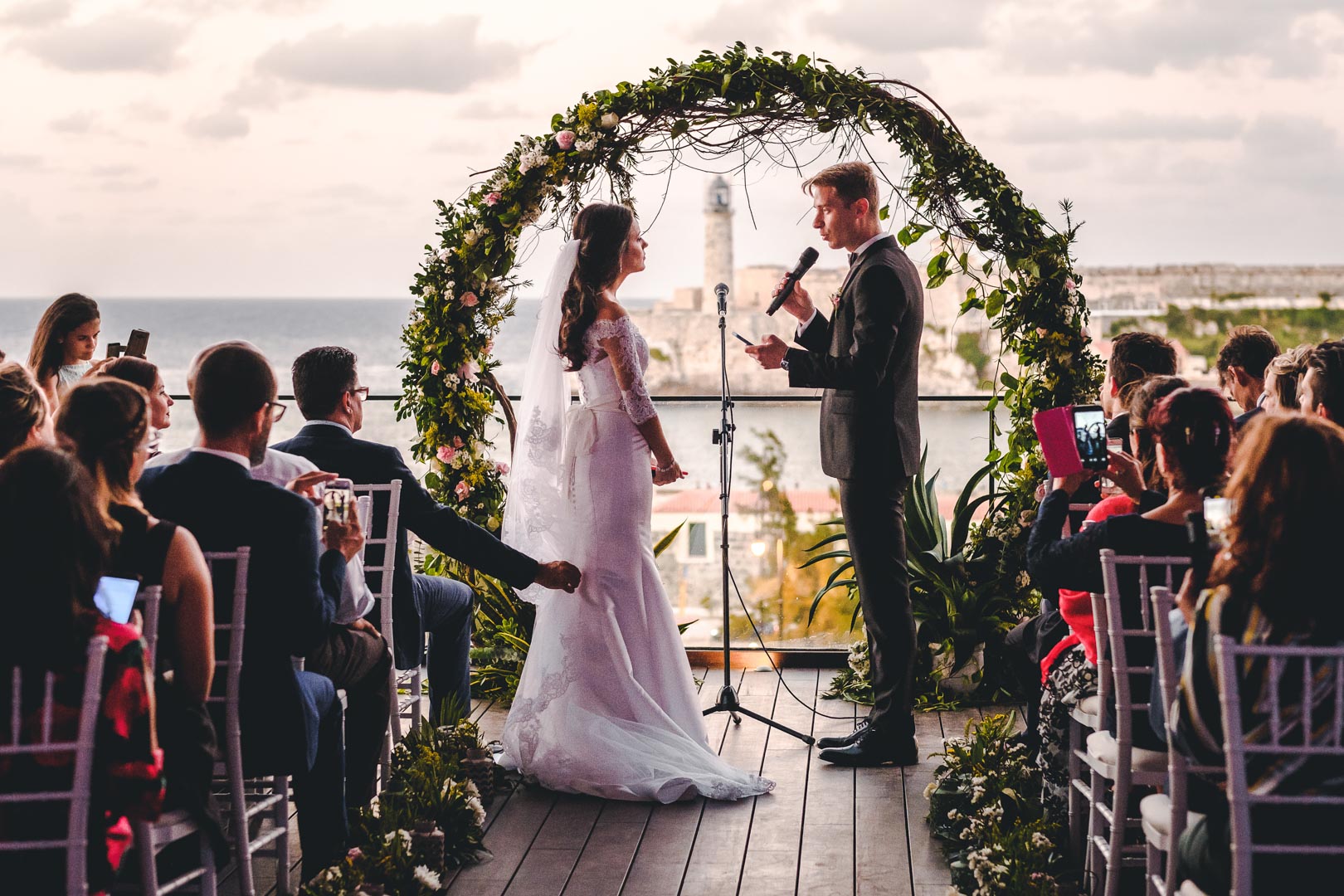 Novios leyendo sus votos en la terraza con vista al mar en el Hotel Grand Packard