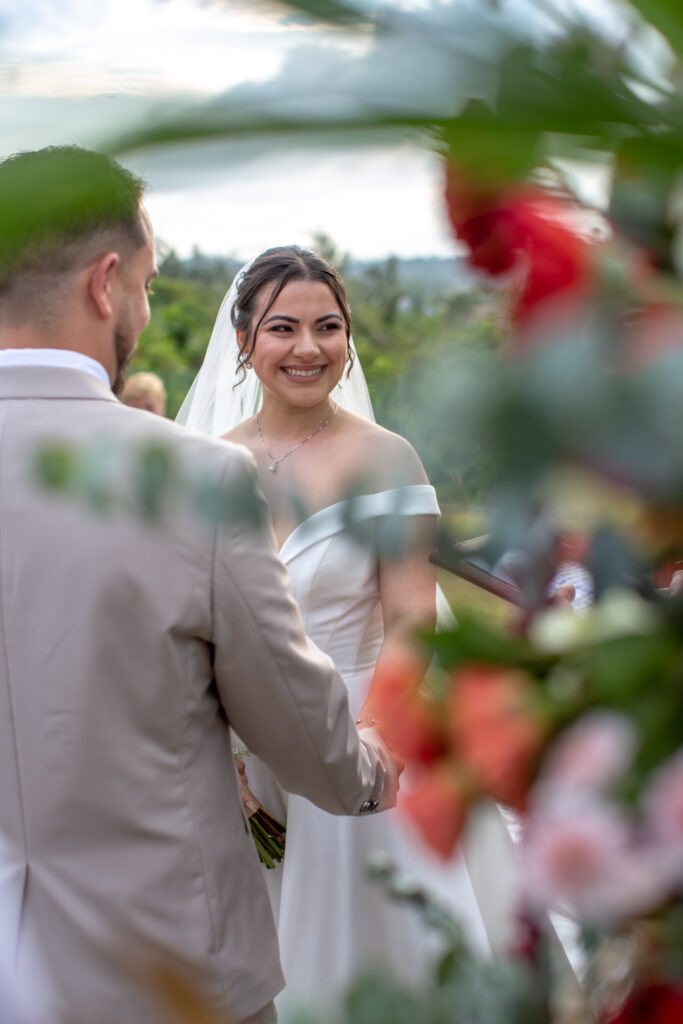 Novia sonríe mientras sostiene las manos del novio en la ceremonia en Viñales