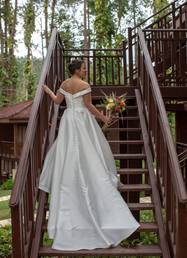 Novia sostiene su ramo mientras sube las escaleras en Viñales
