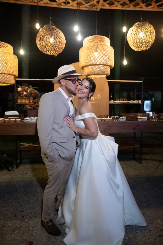 Novios posando felices junto a la mesa de postres en su boda en Viñales