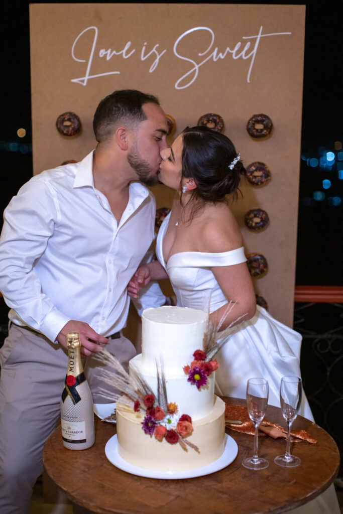 Novios besándose junto al pastel de boda en Viñales con decoración floral