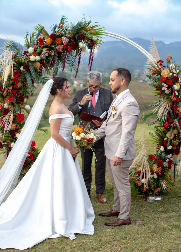 Novios frente al arco floral durante la ceremonia de boda en Viñales