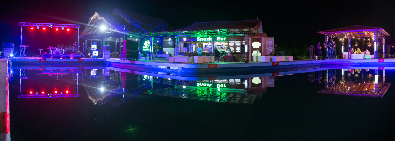 Escenario iluminado y snack bar durante la fiesta de boda en Viñales por la noche