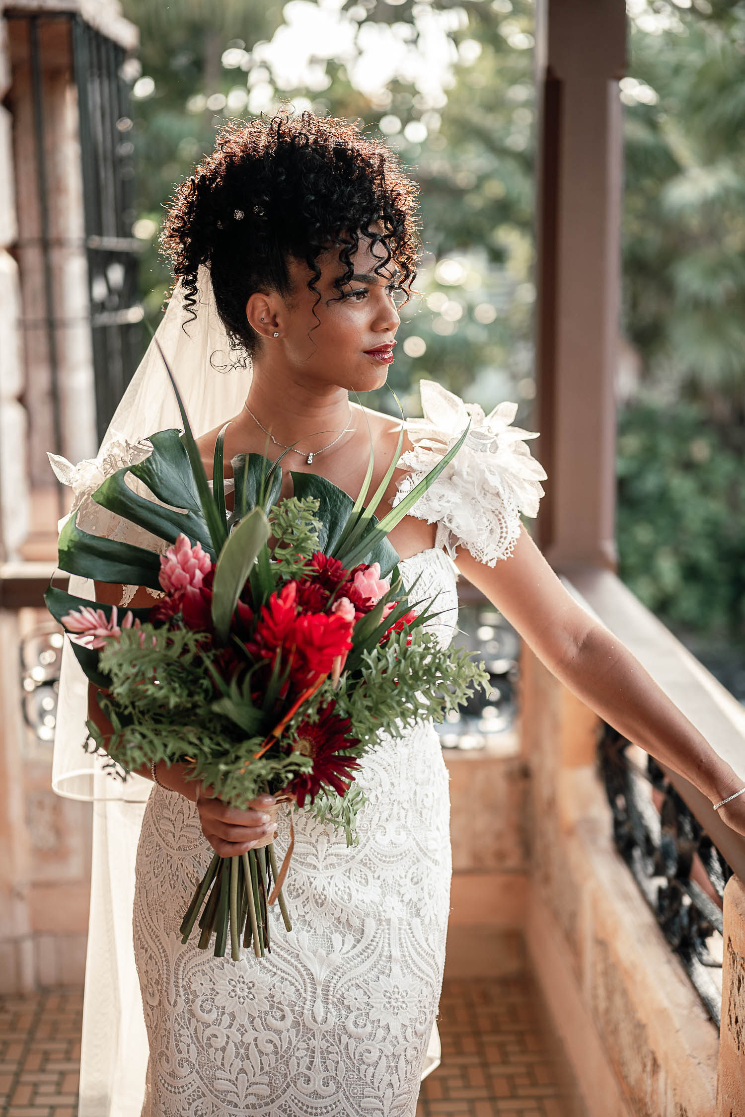 Primer plano de la novia en el balcón sosteniendo su bouquet antes de salir a la boda.