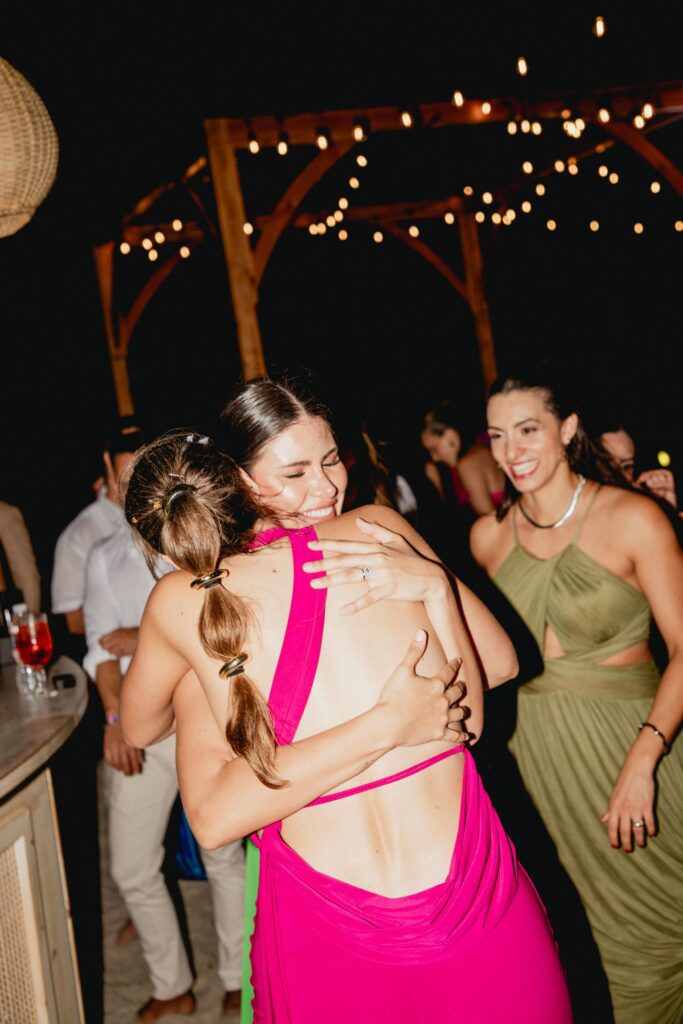 Alba abrazando a sus amigas en un momento emotivo durante la boda en la playa.