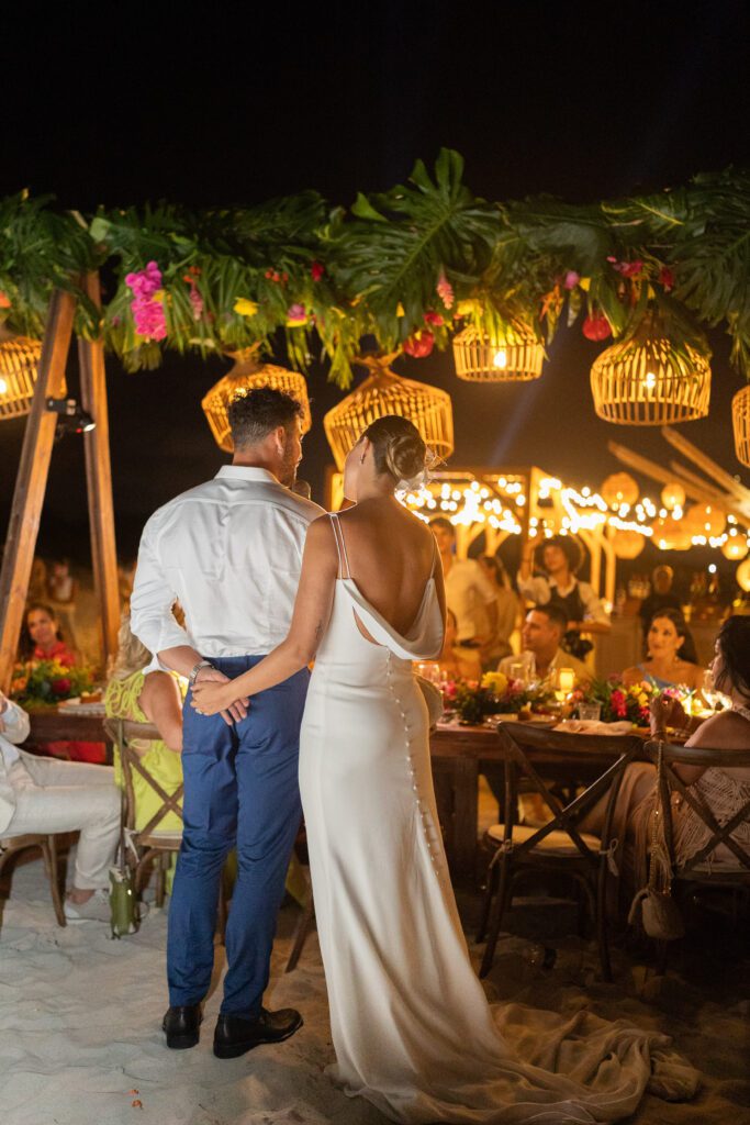 Los novios abrazados junto a la mesa decorada después del brindis de bodas