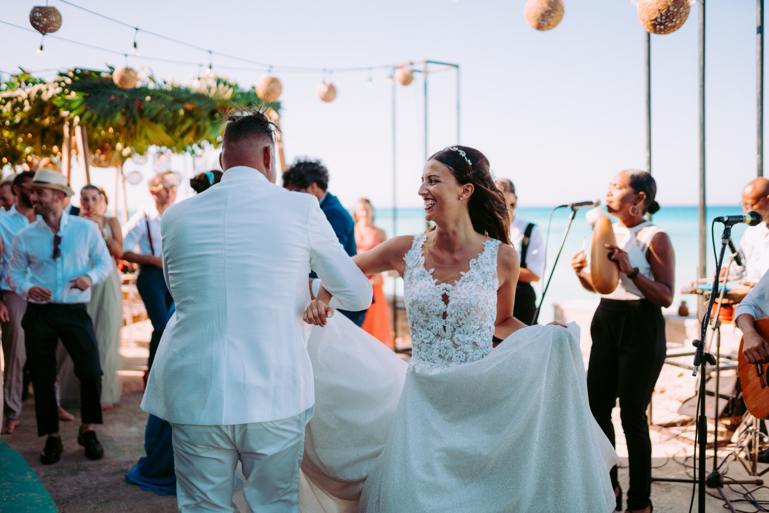 Giada y Gorke bailando felices en su boda frente al mar, acompañados por música en vivo.