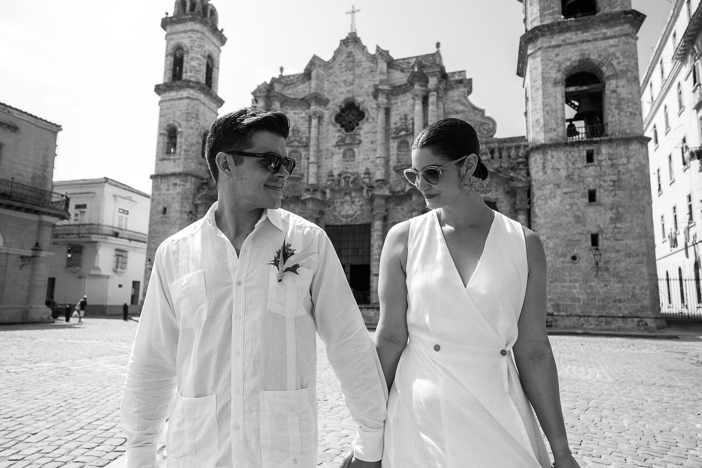 Amanda y Leo en una fotografía en blanco y negro frente a la Catedral de La Habana, parte de su boda en Cuba.