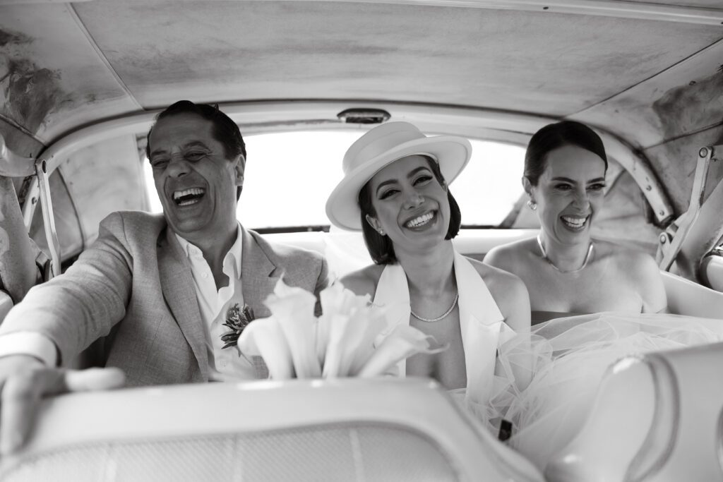 La novia en un auto clásico cubano, acompañada por sus padres, rumbo a la ceremonia de su boda en La Habana, Cuba.