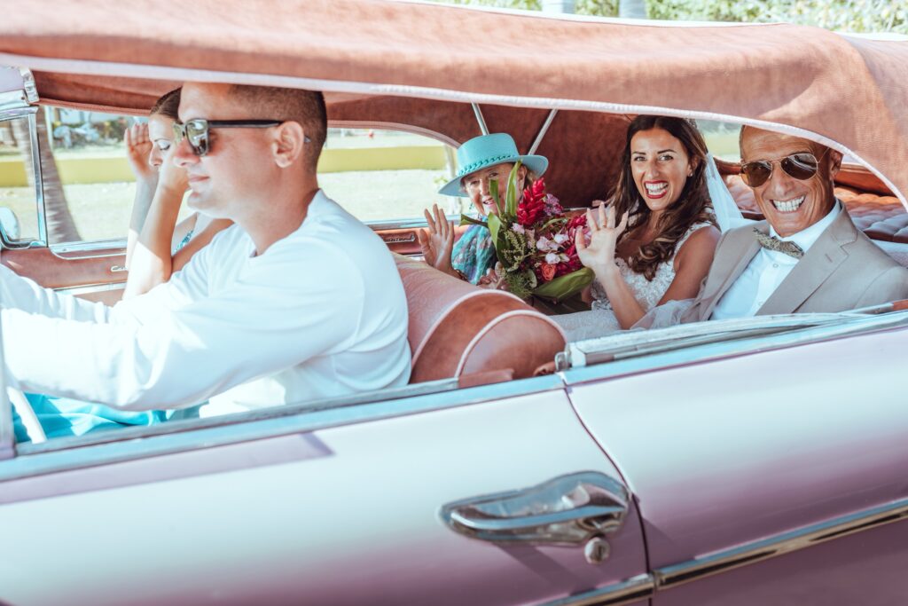 La novia en un carro de época, acompañada de sus padres y hermana, camino a la ceremonia de su boda de destino en Varadero.