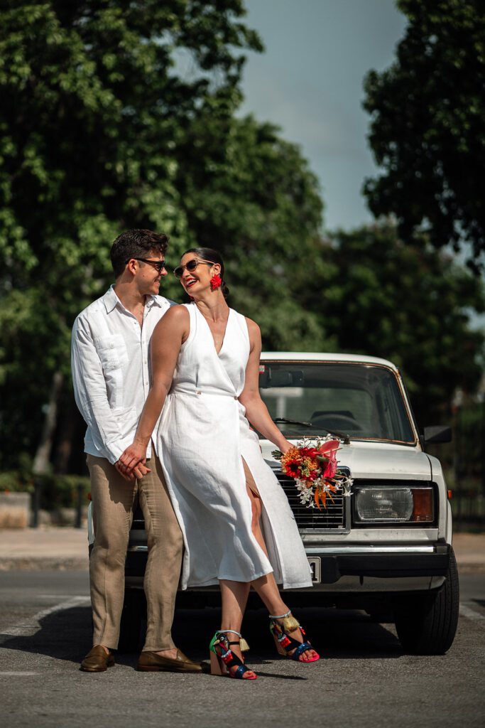 Amanda y Leo posan junto a un Lada clásico en su recorrido de boda.