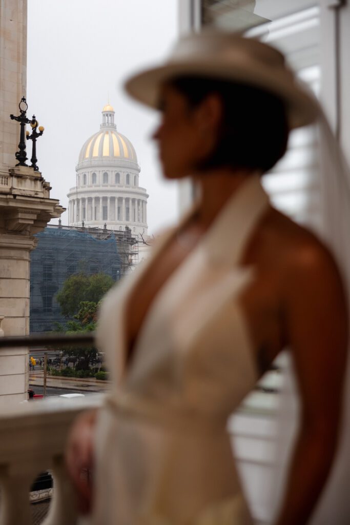 Retrato de Victoria luciendo un sombrero y velo sobre su vestido de Lorenzo Caprile, lista para su boda de destino en La Habana, Cuba