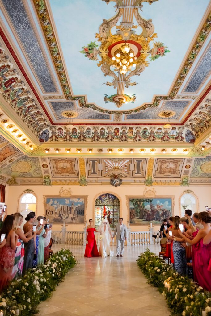 Victoria entrando al Palacio de los Matrimonios de Prado en La Habana, Cuba, acompañada por sus padres durante su ceremonia de boda.