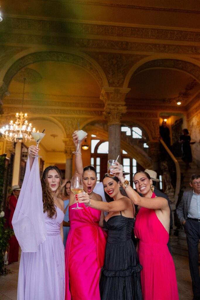 Damas de honor brindando en el cóctel de la boda de destino en La Guarida, La Habana.