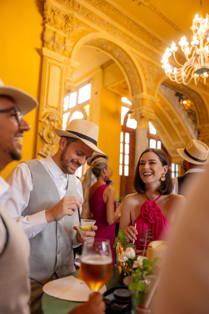 Invitados en el cóctel de la boda de destino en La Habana, disfrutando de mojitos y daiquirís un ambiente elegante.