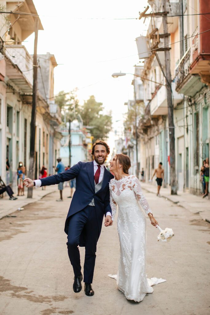 Los novios caminando alegremente por las calles de La Habana, Cuba, después de su boda.