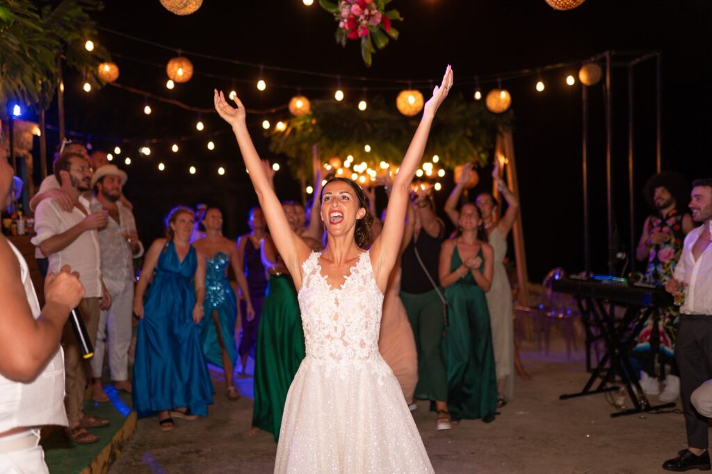 Giada sonríe mientras lanza su ramo durante su boda de destino en Varadero, rodeada de amigos y familiares.