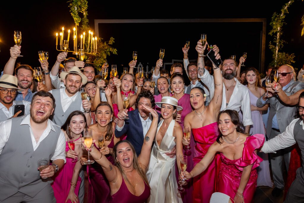 Todos los invitados levantando sus copas en un brindis grupal durante la boda de destino en La Habana.