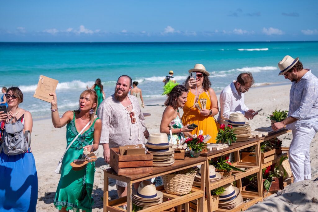 nvitados eligen abanicos de madera y sombreros en la mesa de regalos durante la boda de Giada y Gorke en Varadero.