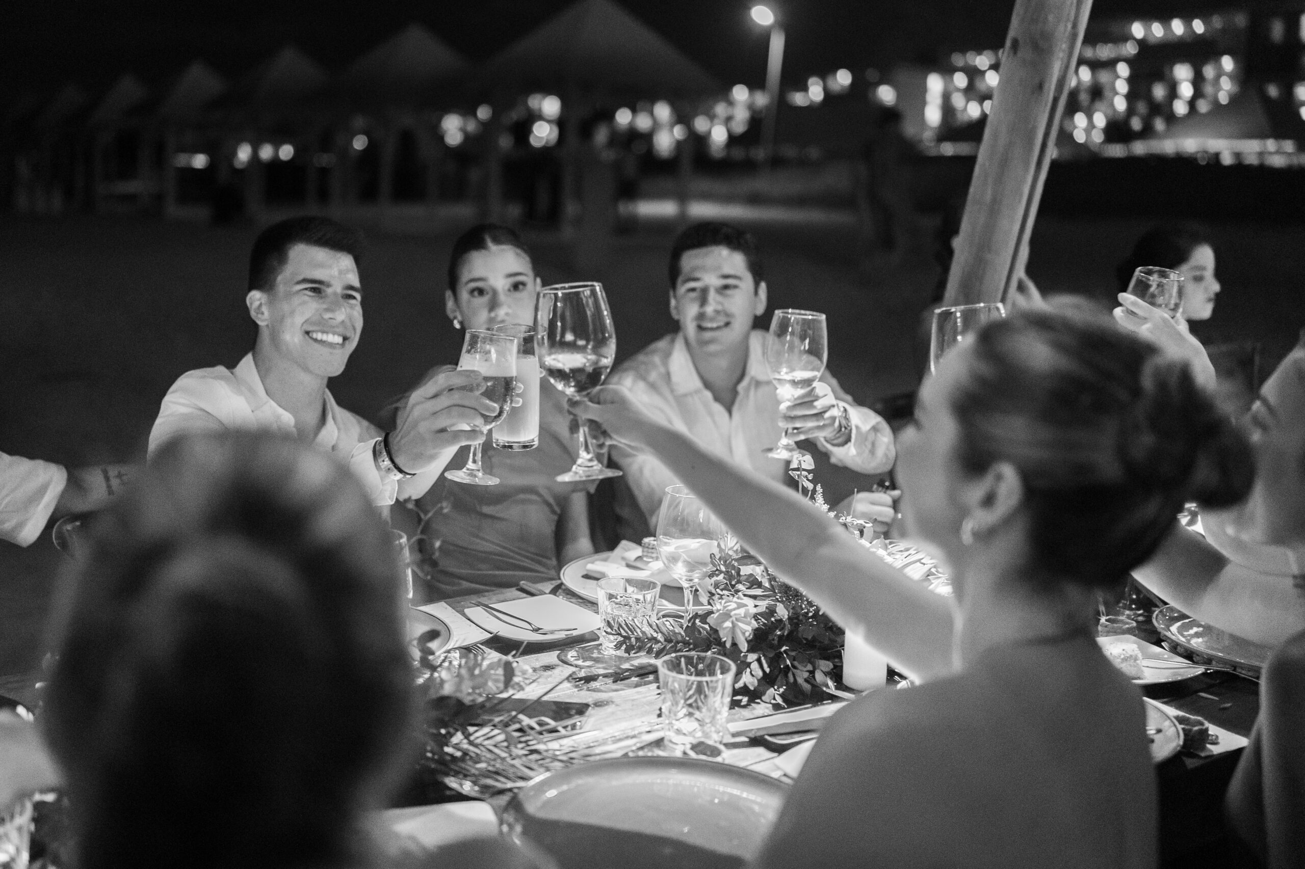 Invitados levantando sus copas para brindar por Alba y Renato durante la celebración de la boda en Cuba.