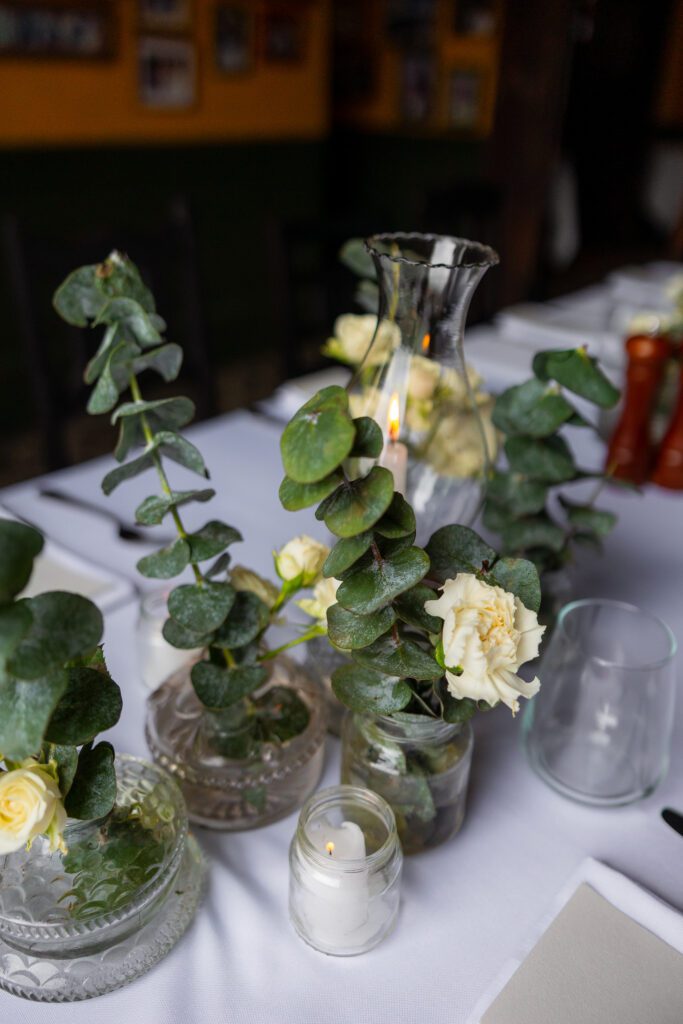 Quinqués antiguos y flores blancas en la decoración de mesa de una boda de destino en La Guarida, La Habana