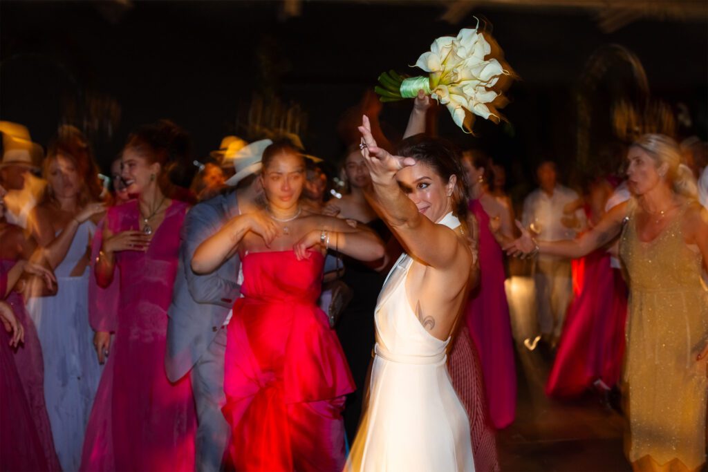 Novia levantando el ramo en actitud festiva durante su boda de destino en La Habana.