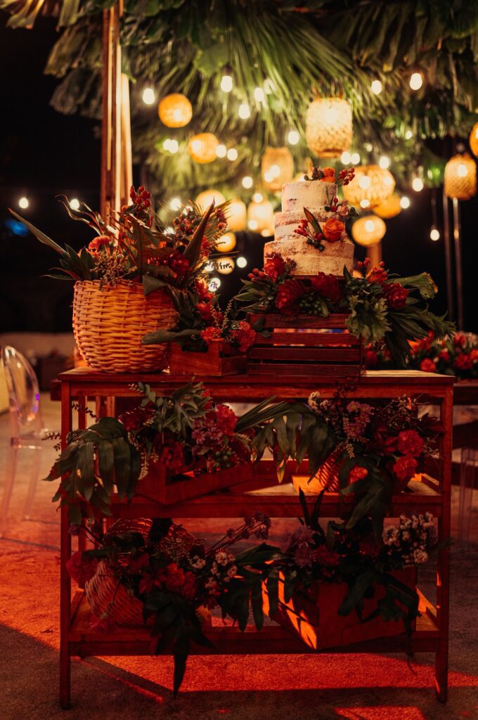 Mueble de cajas de madera decorado con flores tropicales, utilizado como mesa del pastel en la boda de Giada y Gorke en Varadero.