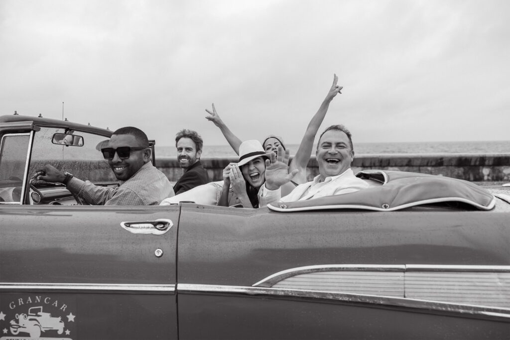 Invitados en auto descapotable en boda de destino en La Habana.