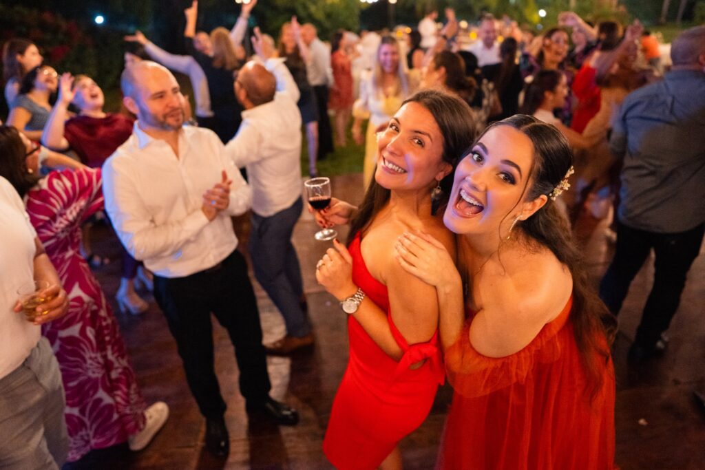 Invitados disfrutando y bailando en una boda romántica de jardín, capturando la alegría de la noche.