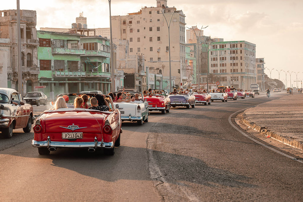 Caravana de autos clásicos durante una boda de destino cubana en el Malecón habanero.