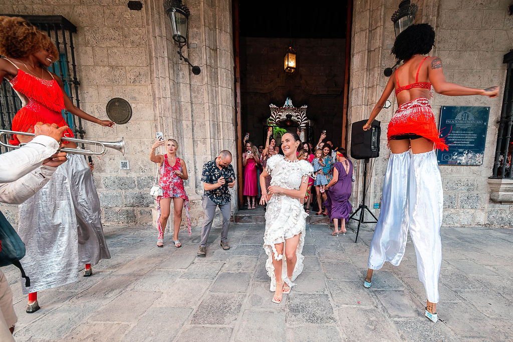 Novia sale del Palacio del Segundo Cabo entre zancos y música en una boda de destino cubana