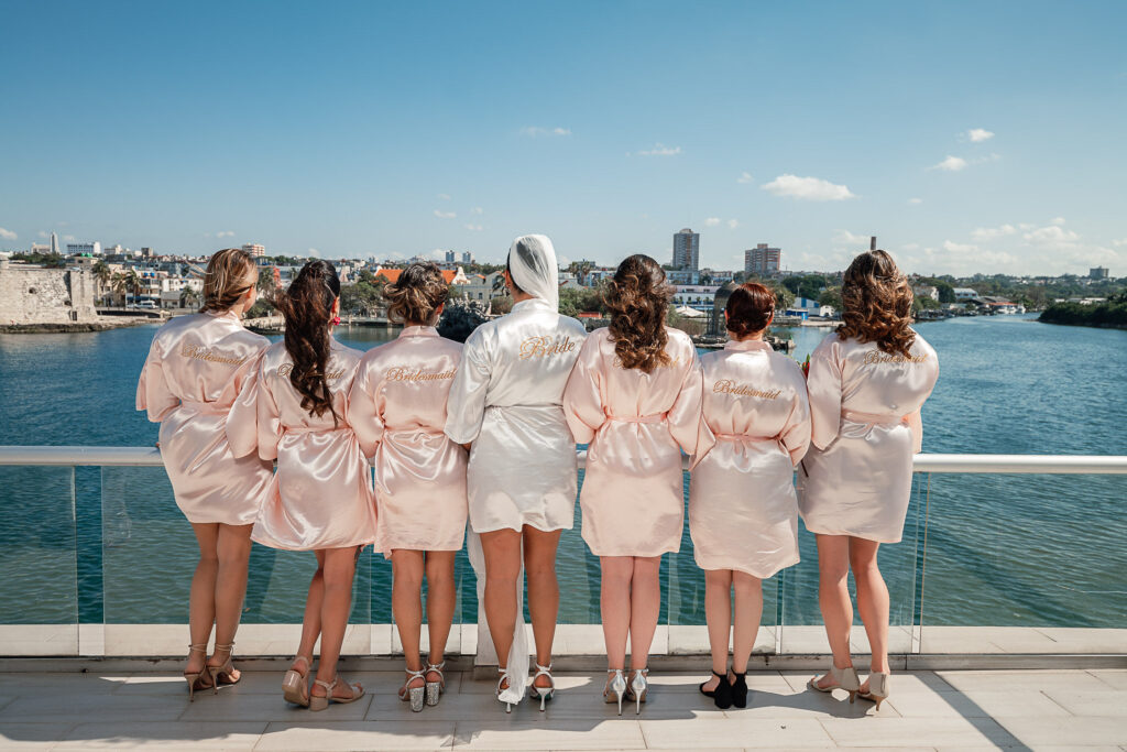 Bride and bridesmaids on the balcony during the getting ready, with views of the sea and the city