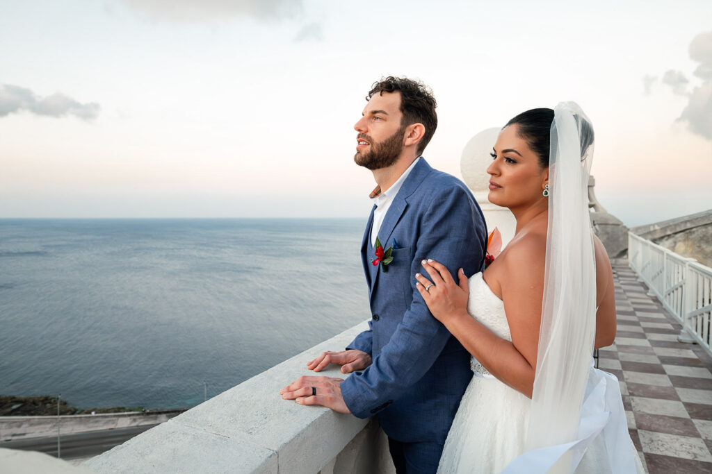 The couple looks out to sea from a high floor of the Hotel Nacional on their wedding day