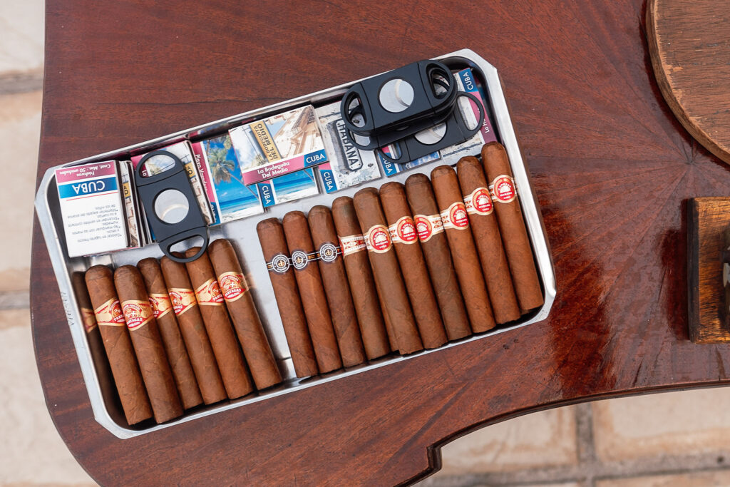 Tobacco ritual with custom cigarette packs and vintage postcards at a Cuban wedding