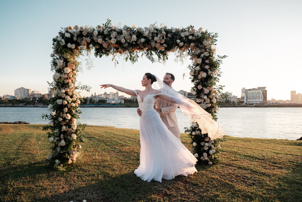 Novios posan frente al gazebo nupcial con la ciudad de fondo
