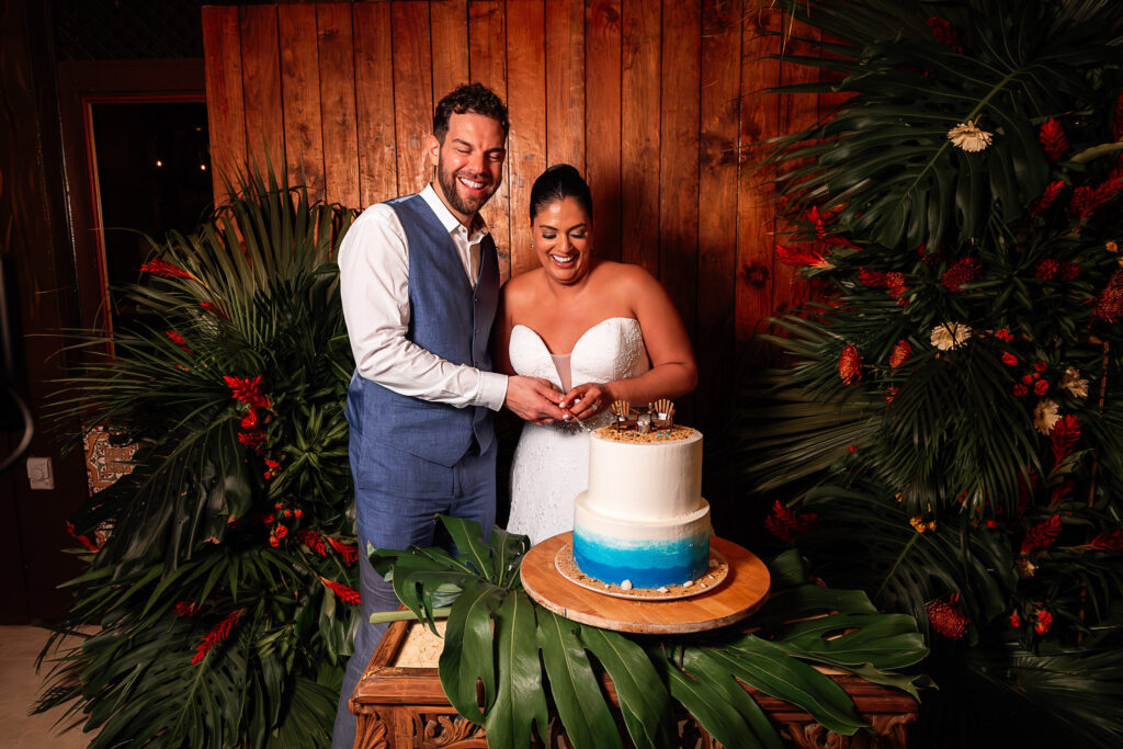 Couple cutting ocean-themed cake with tropical décor at their Hotel Nacional wedding