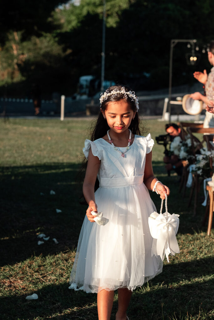 Niña lanza pétalos blancos en el pasillo nupcial durante boda en Cuba