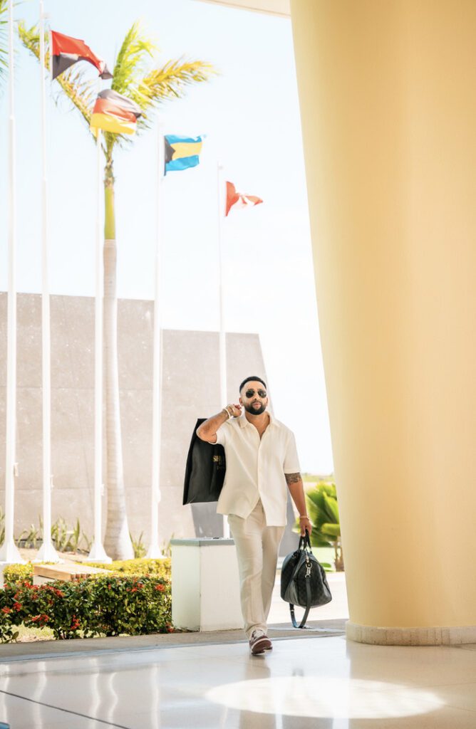 Aaron arrives at the hotel with his jacket over his shoulder and bag in hand, ready for the wedding
