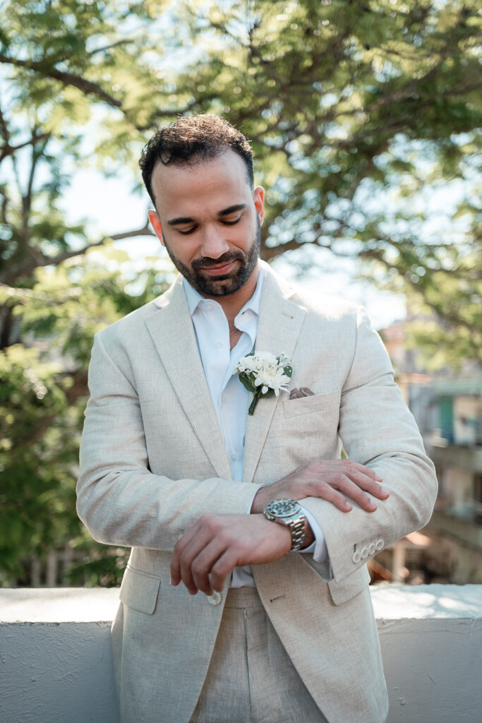 El novio revisa la hora durante sus preparativos antes de la boda en Cuba