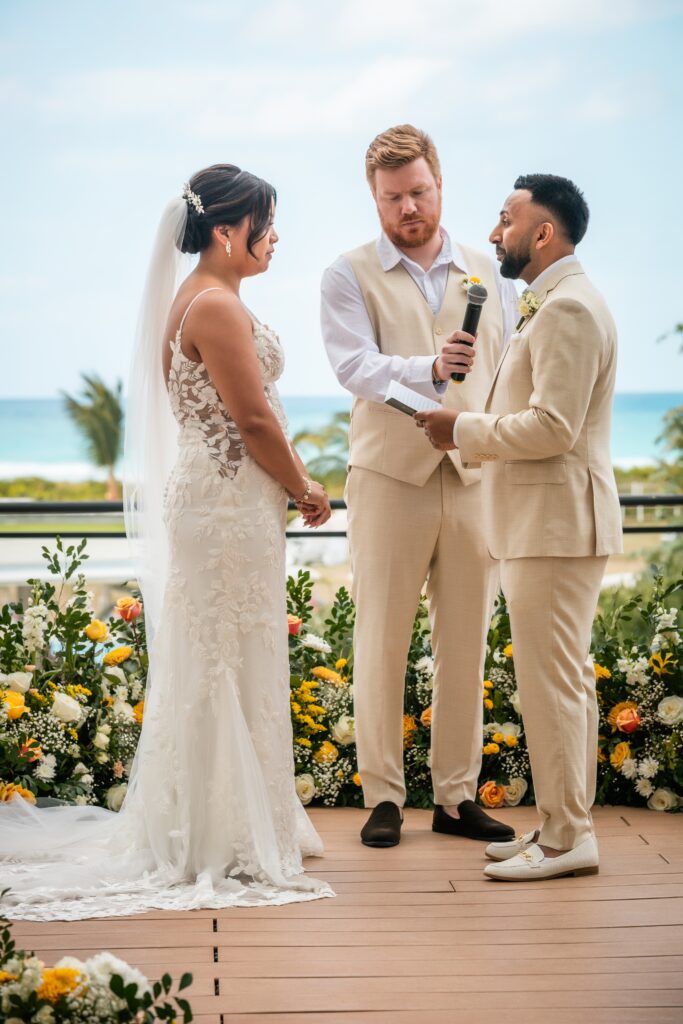 Aaron reads his vows by the sea, in front of Stephanie and their guests