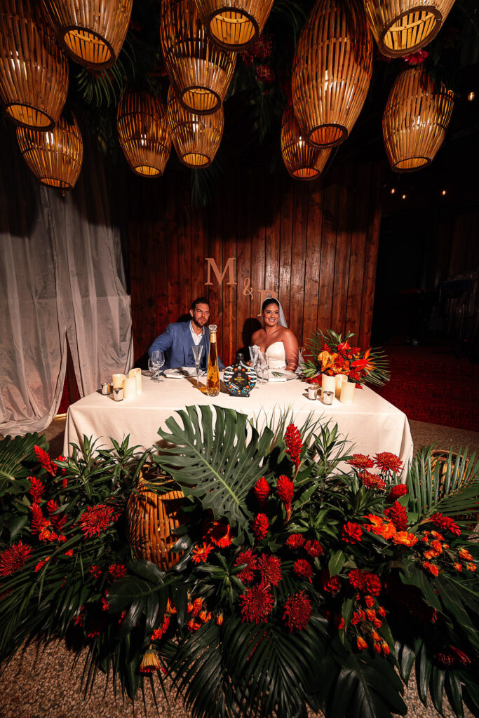Head table with tropical flowers, couple’s monogram, and hanging lamps at Hotel Nacional wedding