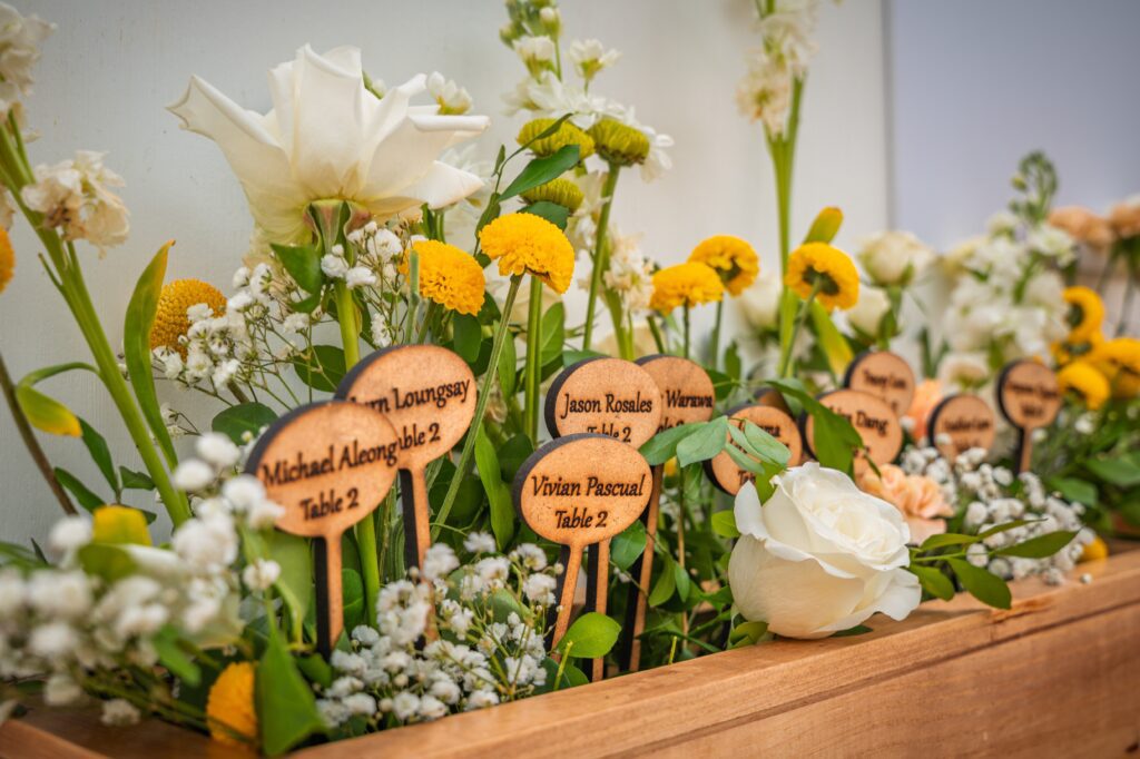 Seating plan sign decorated with flowers and engraved names